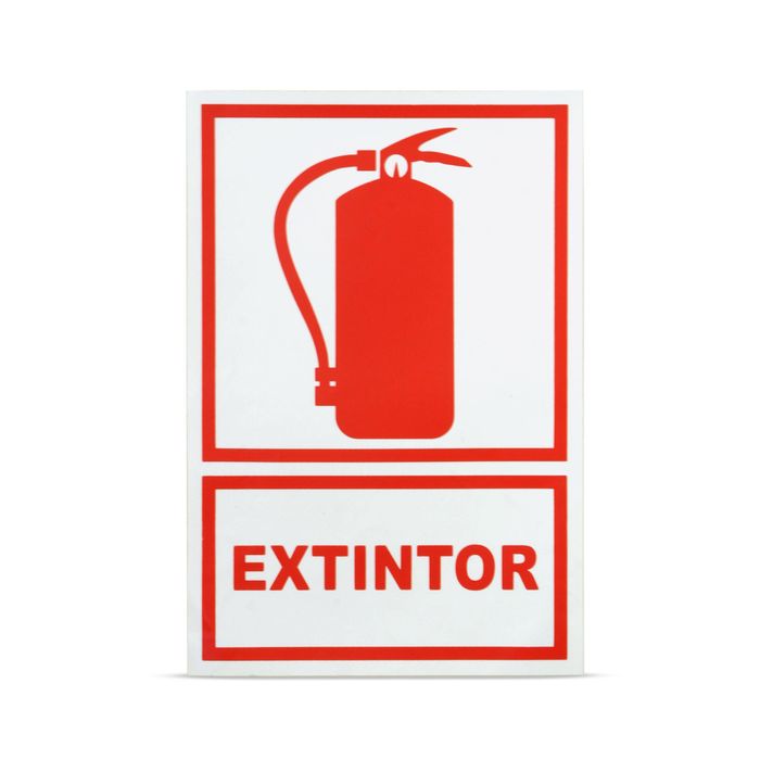 Codificación cromática de las señales de peligro: Un extintor rojo junto a una manguera de incendios, con una señal de seguridad verde fotoluminiscente de ruta de evacuación en el fondo, mostrando el brillo en la oscuridad.